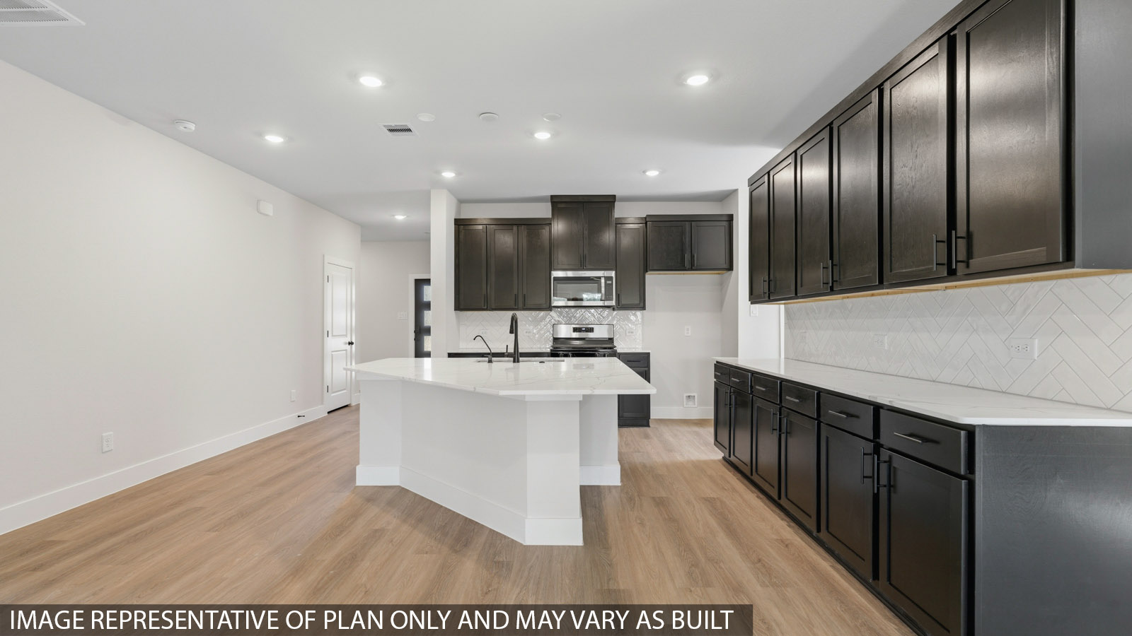 Kitchen with stainless steel appliances, quartz countertops and modern hardware and an island and vinyl floor