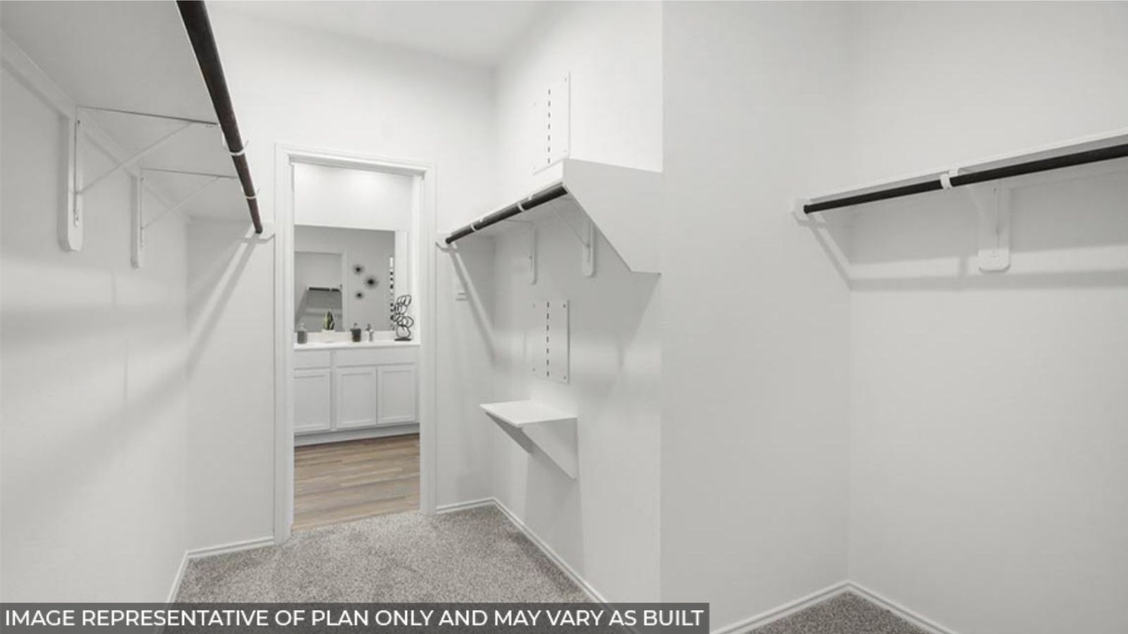 Primary bedroom walk-in closet with carpet flooring in Chapel Lakes community in Montgomery TX