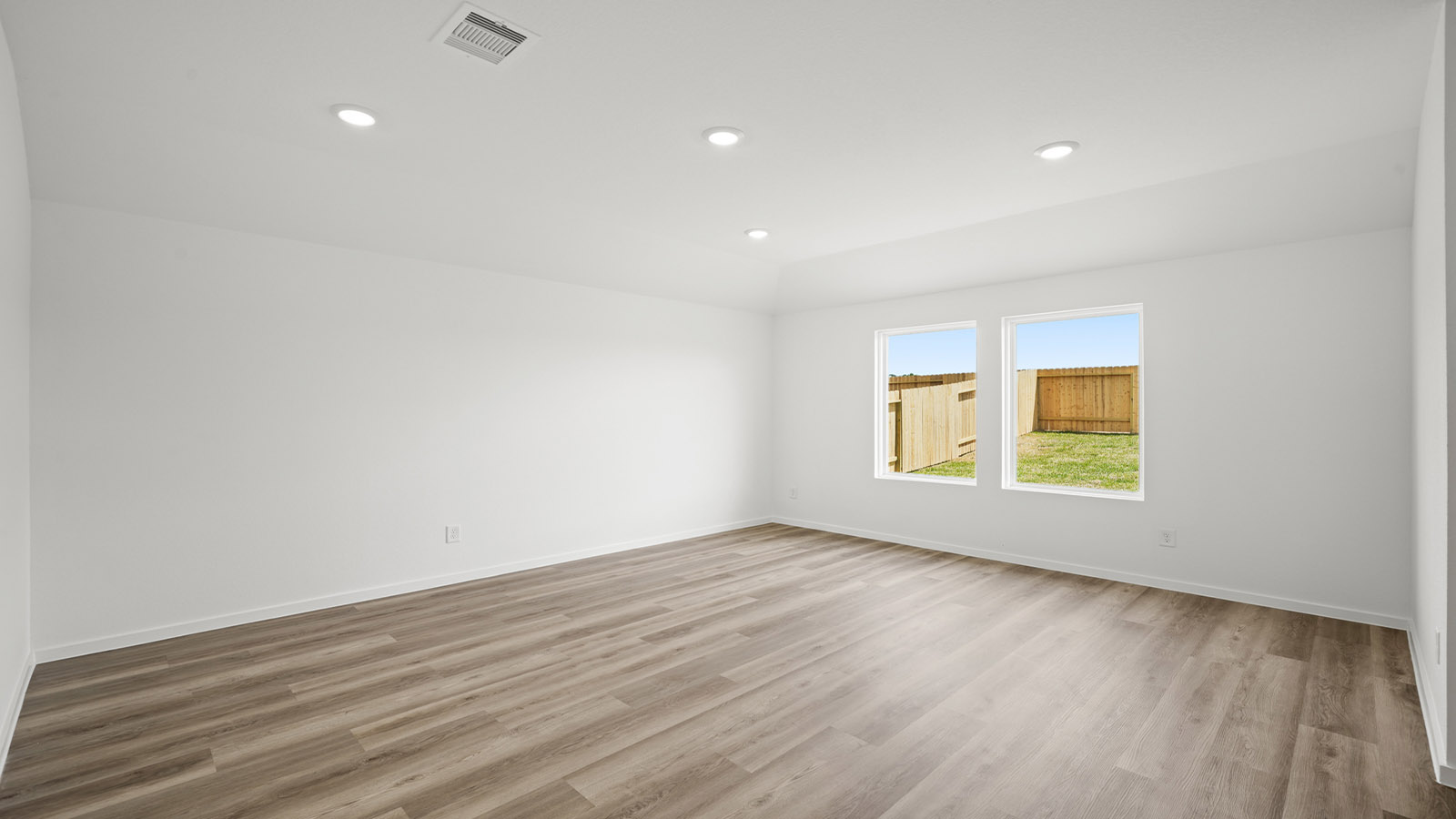 Spacious living area with vinyl flooring