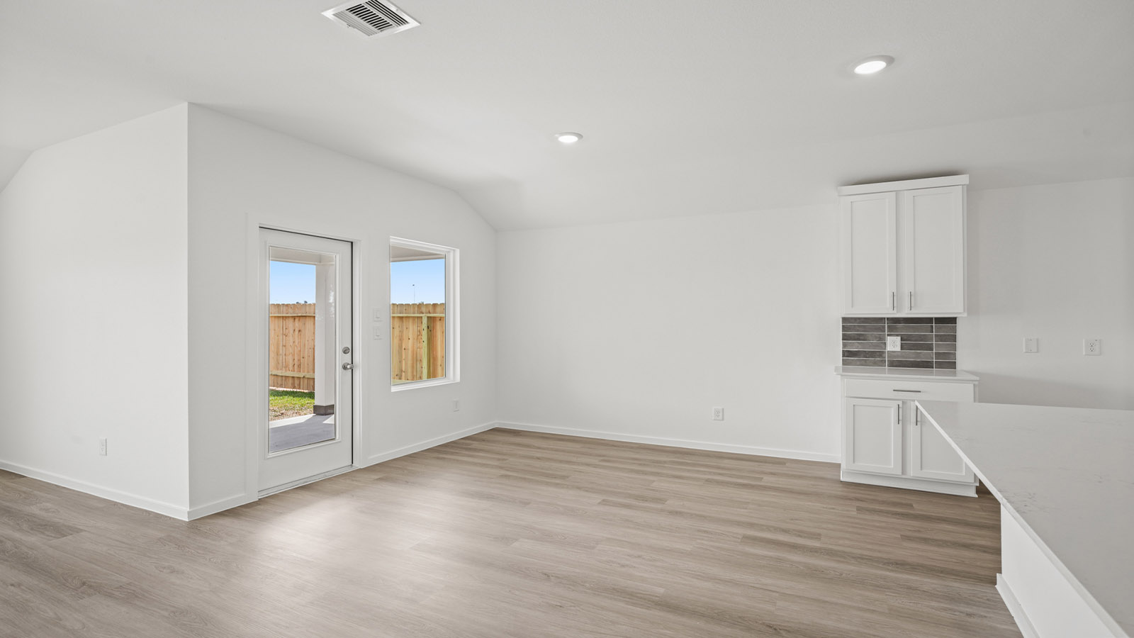 Spacious living area with vinyl flooring