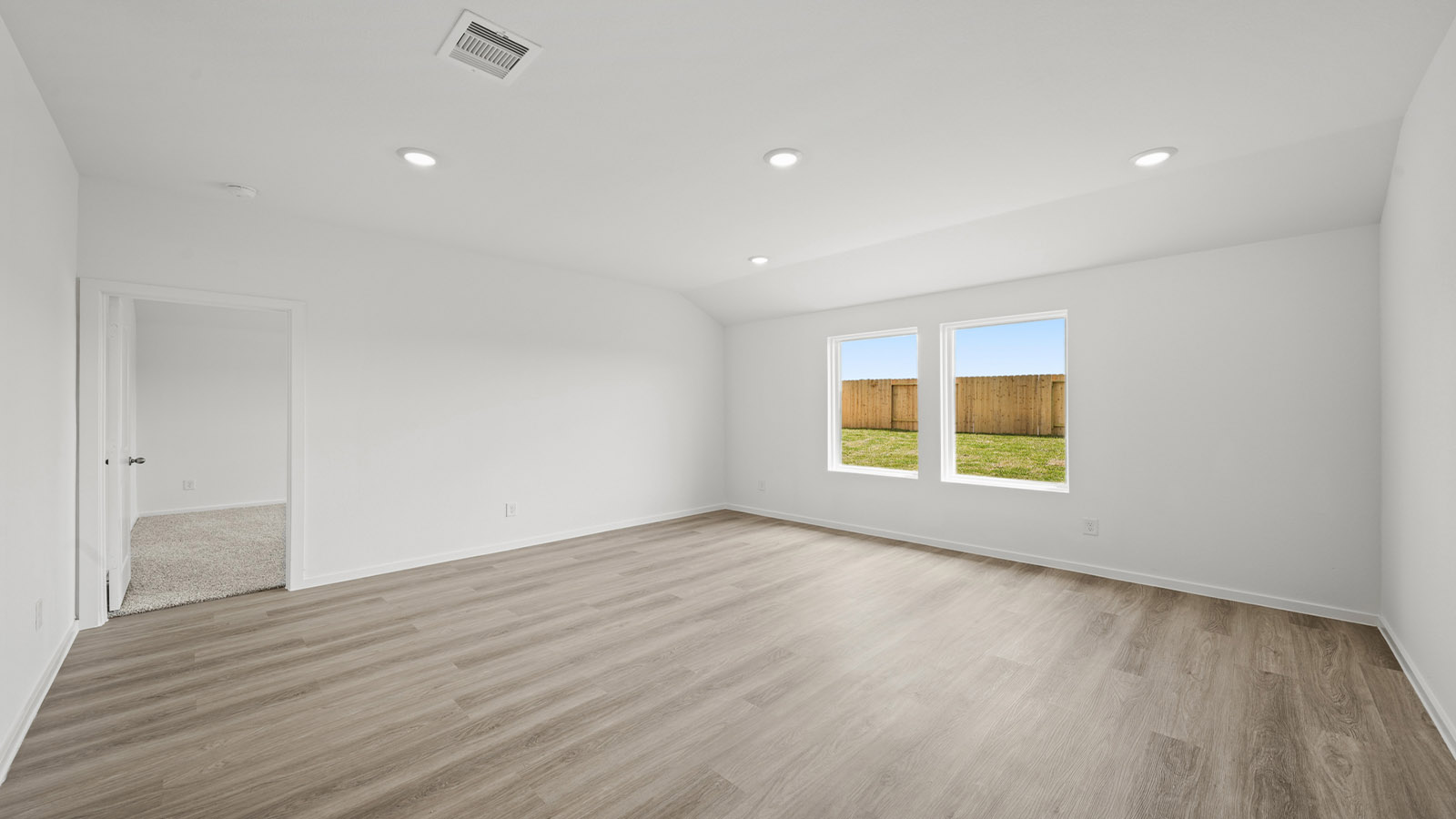 Spacious living area with vinyl flooring