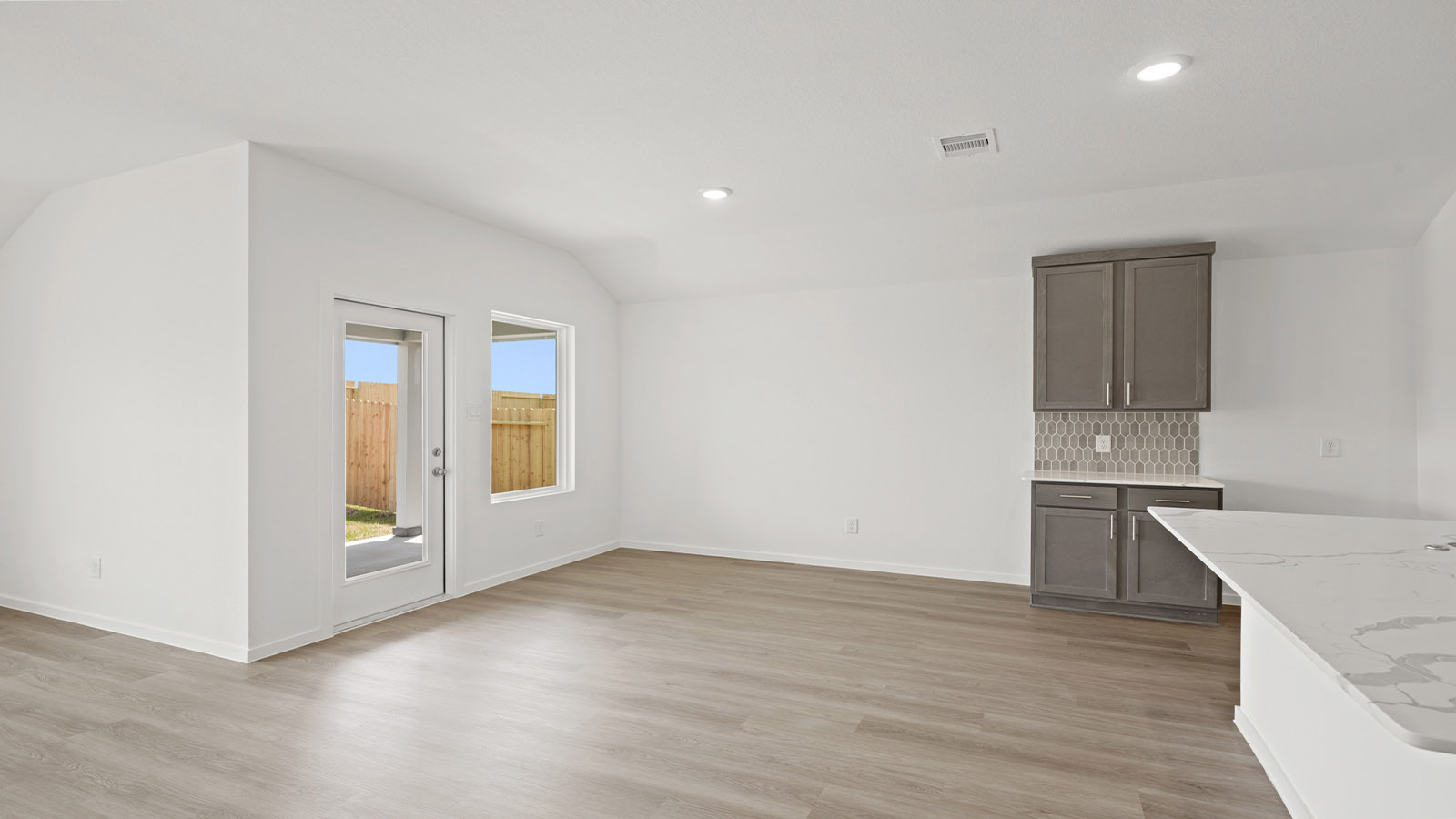 Spacious living area with vinyl flooring