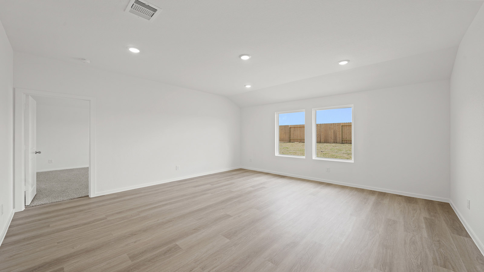 Spacious living area with vinyl flooring