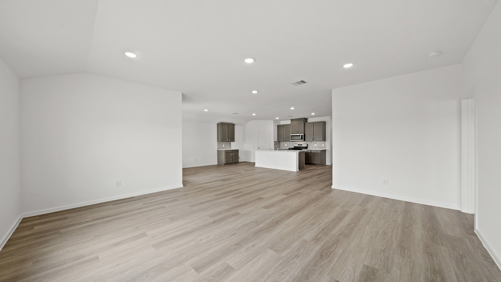 Spacious living area with vinyl flooring