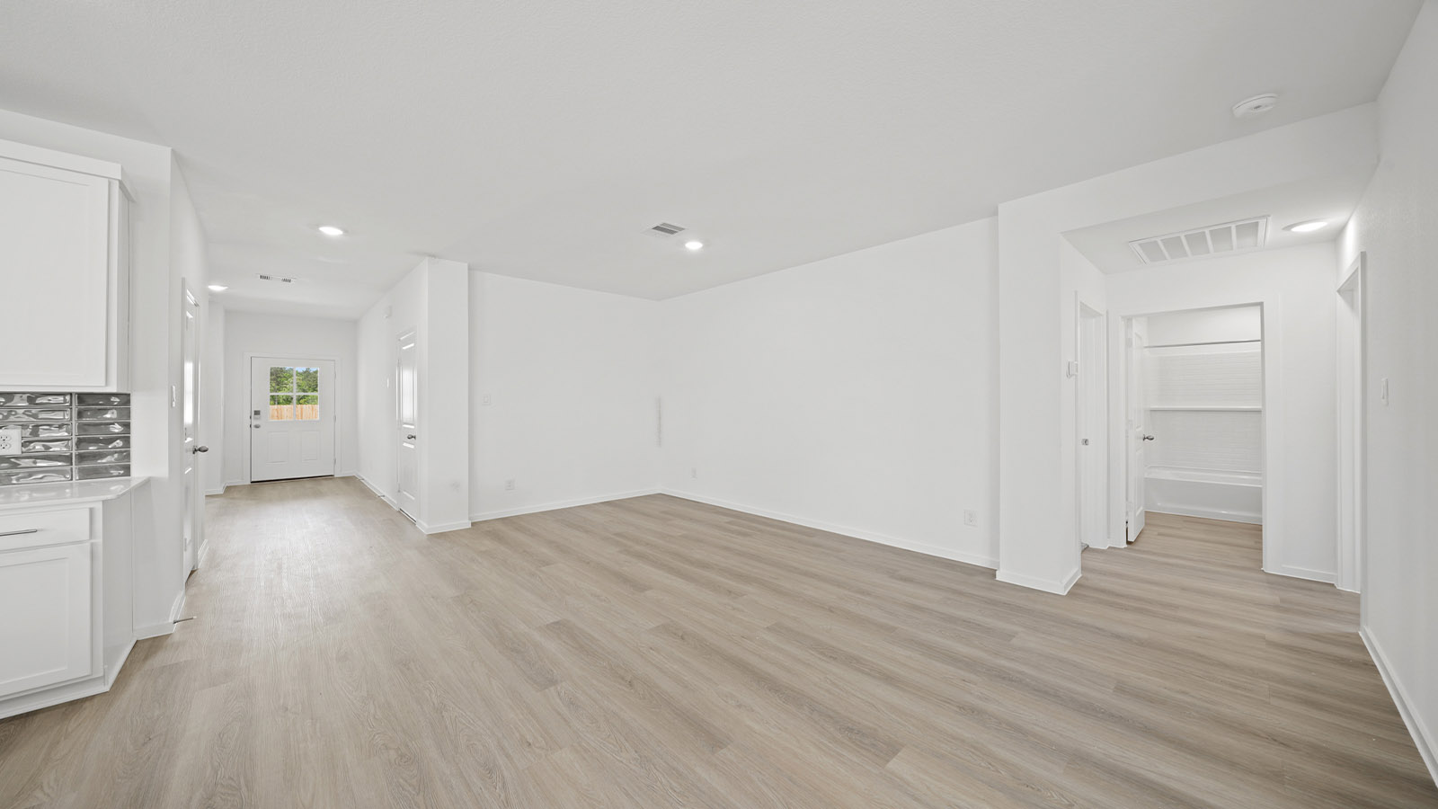 Spacious living area with vinyl flooring