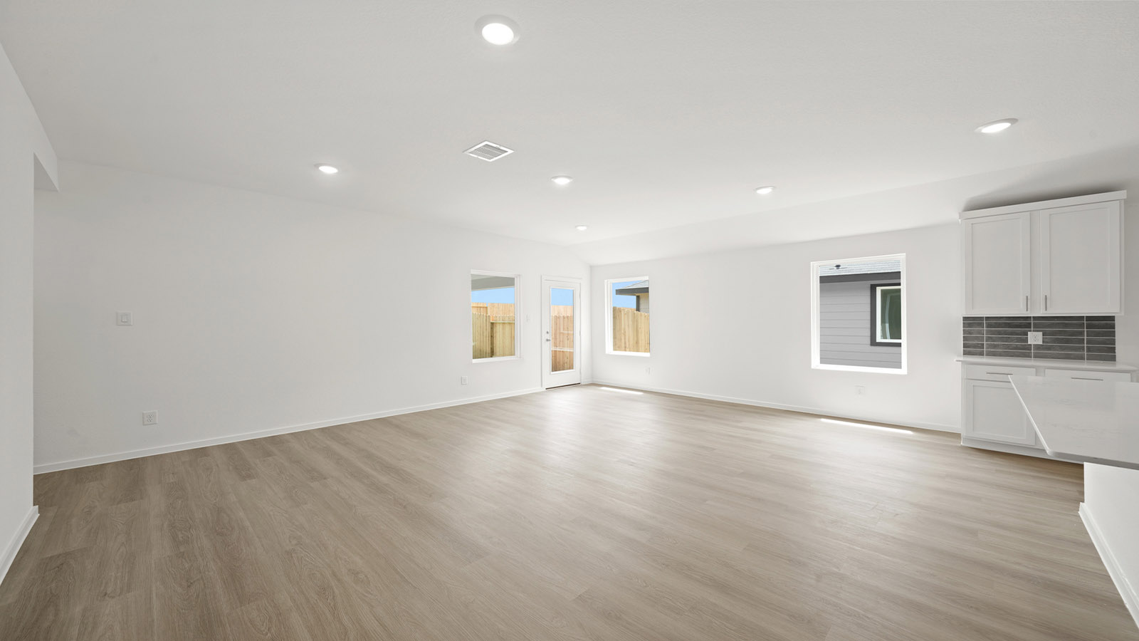 Spacious living area with vinyl flooring
