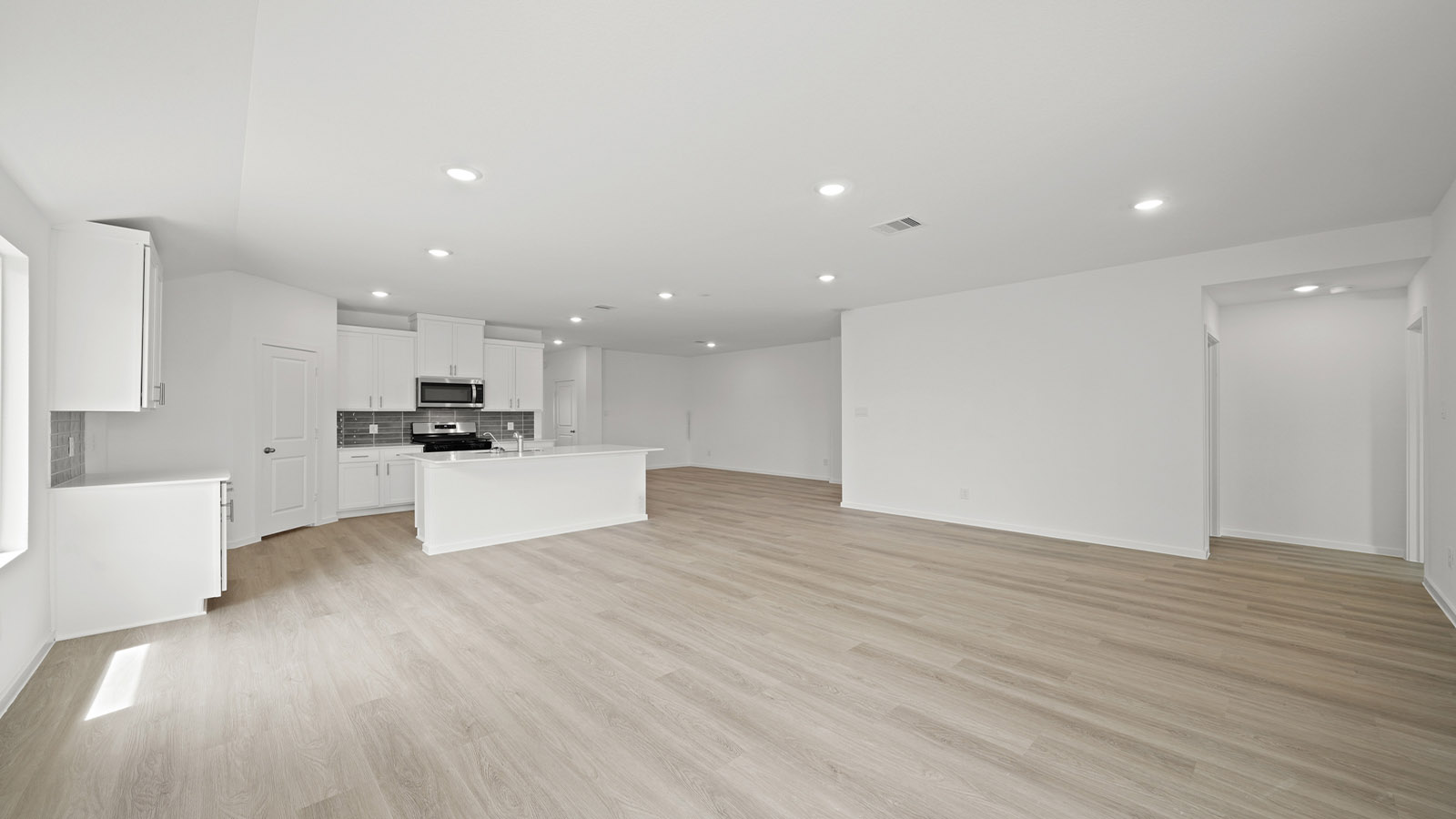 Spacious living area with vinyl flooring