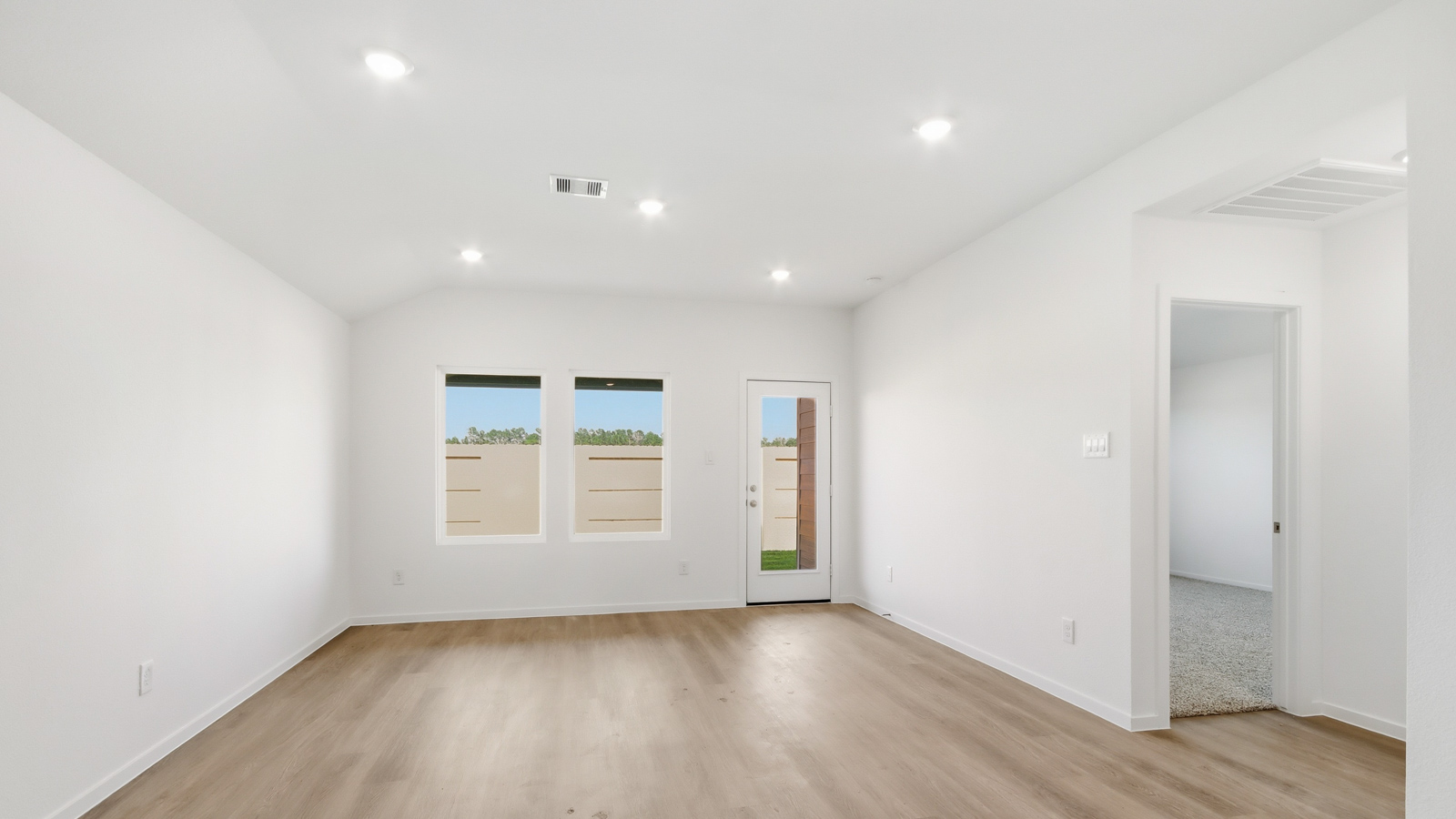 open concept living and dining area with vinyl flooring, quartz countertops, and stainless steel appliances