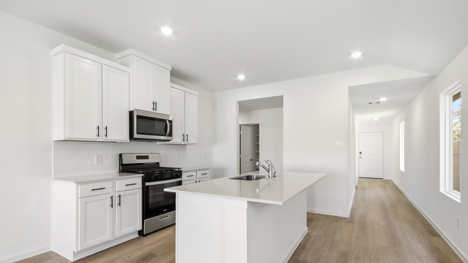 open concept living and dining area with vinyl flooring, quartz countertops, and stainless steel appliances
