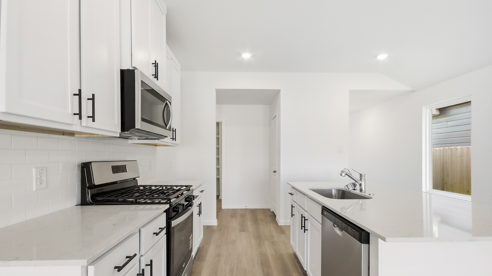 open concept living and dining area with vinyl flooring, quartz countertops, and stainless steel appliances