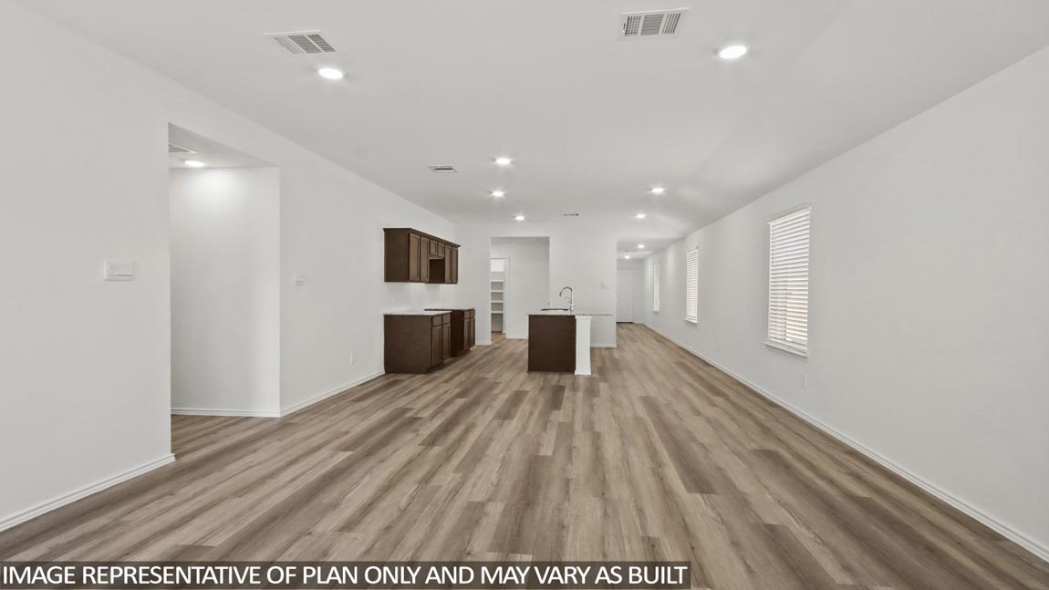 open concept livving and dining area with vinyl flooring, quartz countertops, and large windows in Hockley, TX
