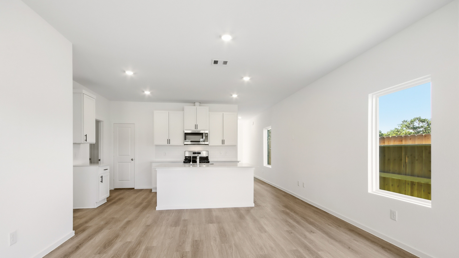 open concept living and dining area with vinyl flooring, and quartz countertops