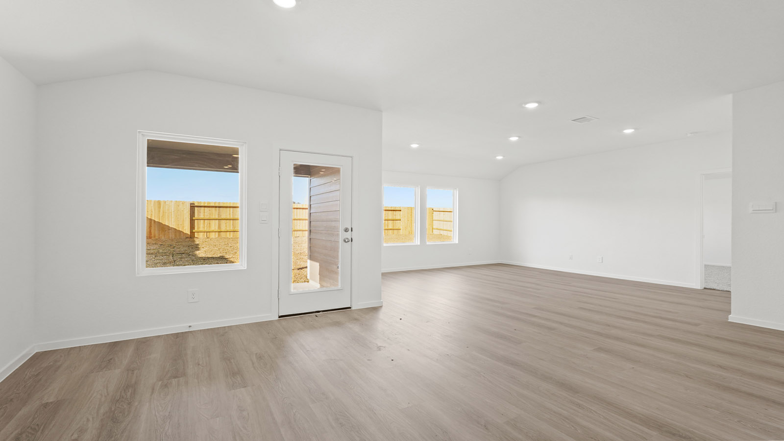 open concept living and dining area with vinly flooring, quartz countertops, and large windows