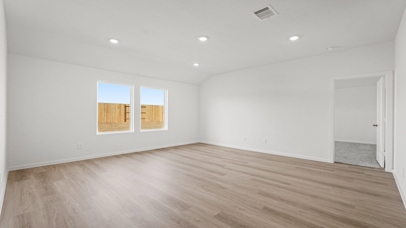 open concept living and dining area with vinly flooring, quartz countertops, and large windows