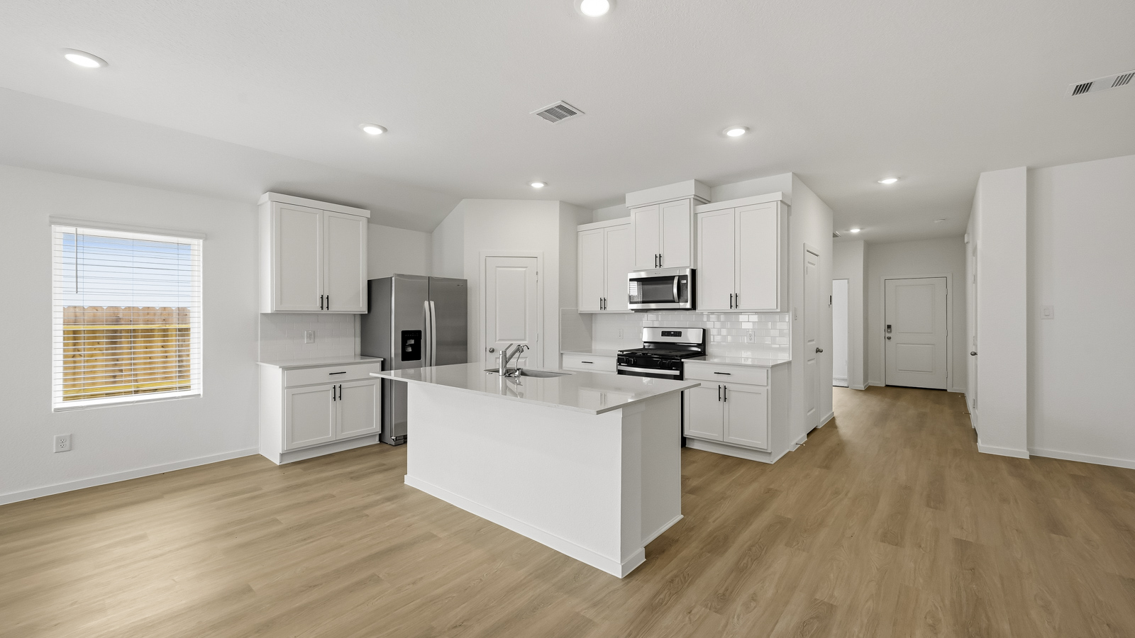 Kitchen with quartz countertops and an island and vinyl floor