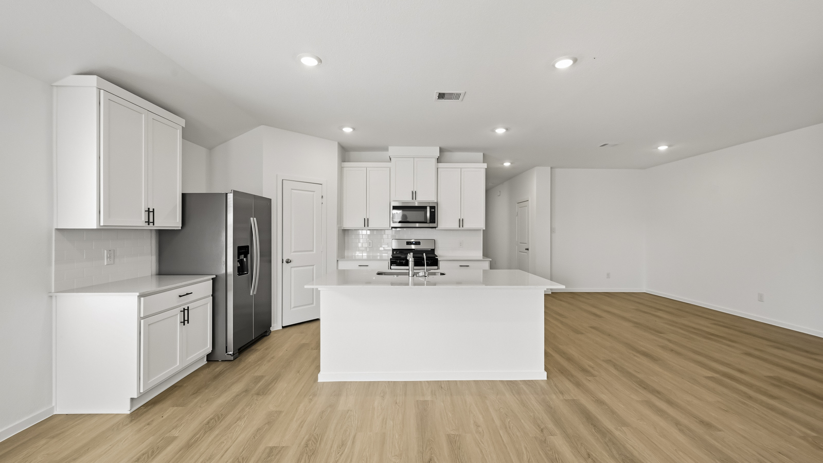 Kitchen with quartz countertops and an island and vinyl floor