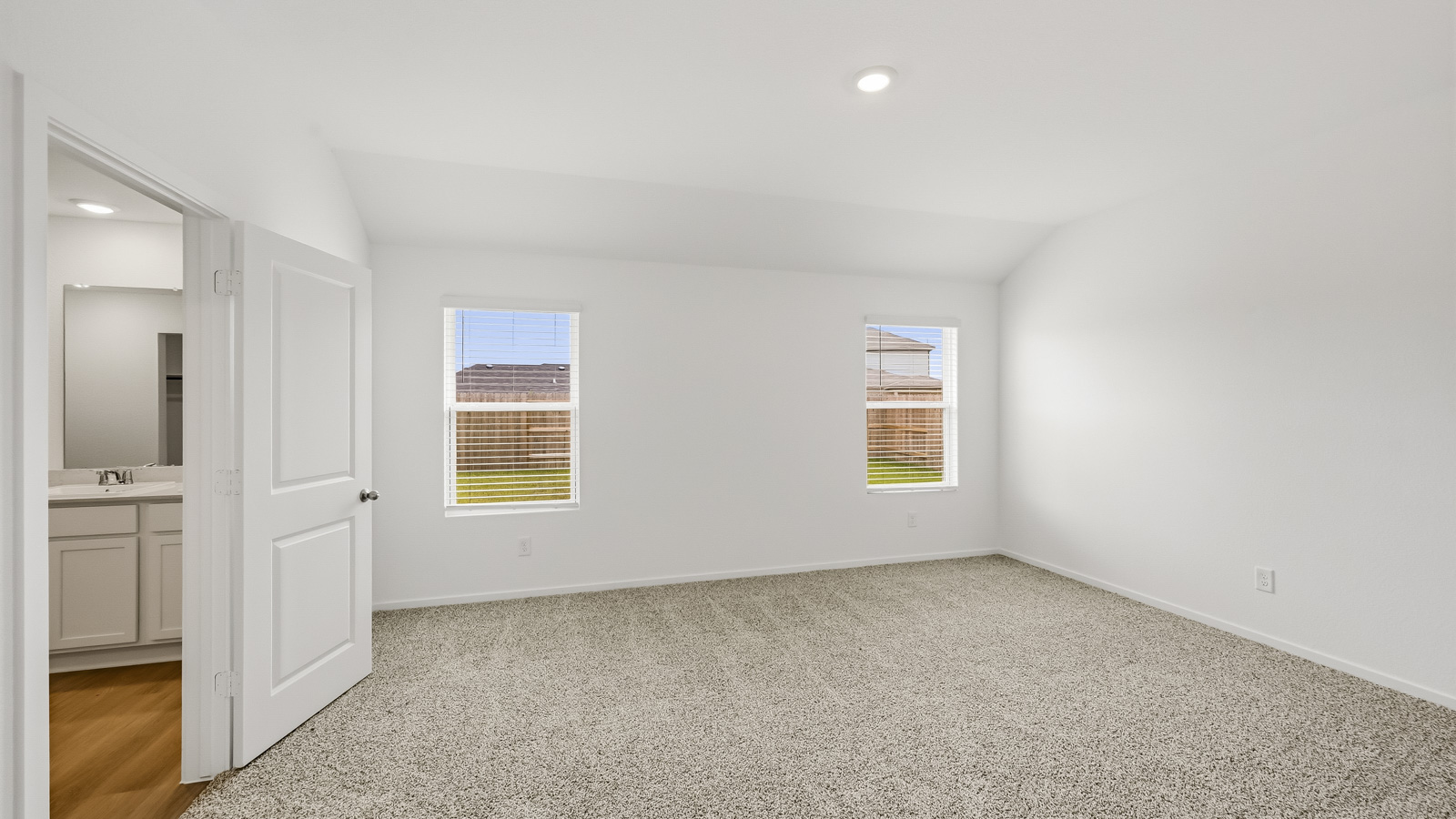 Large Primary bedroom with shag carpet flooring and bright window