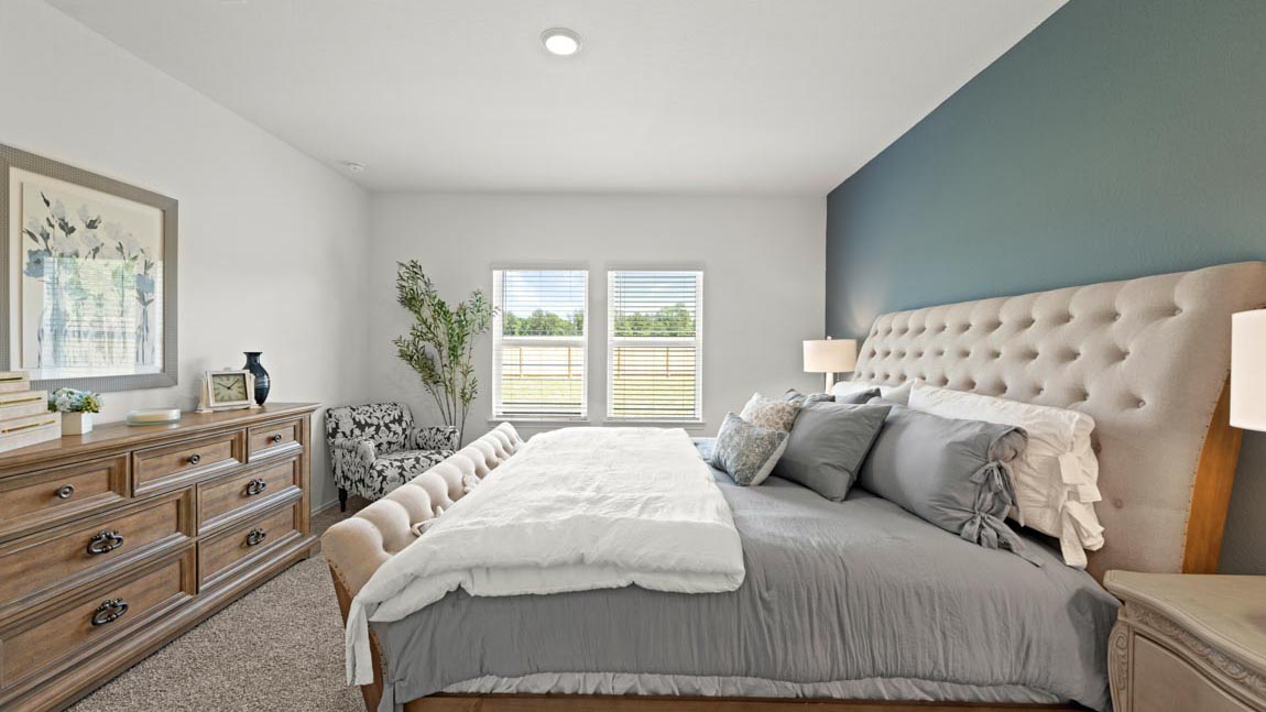 Primary bedroom with carpet flooring and large windows in Hockley, TX