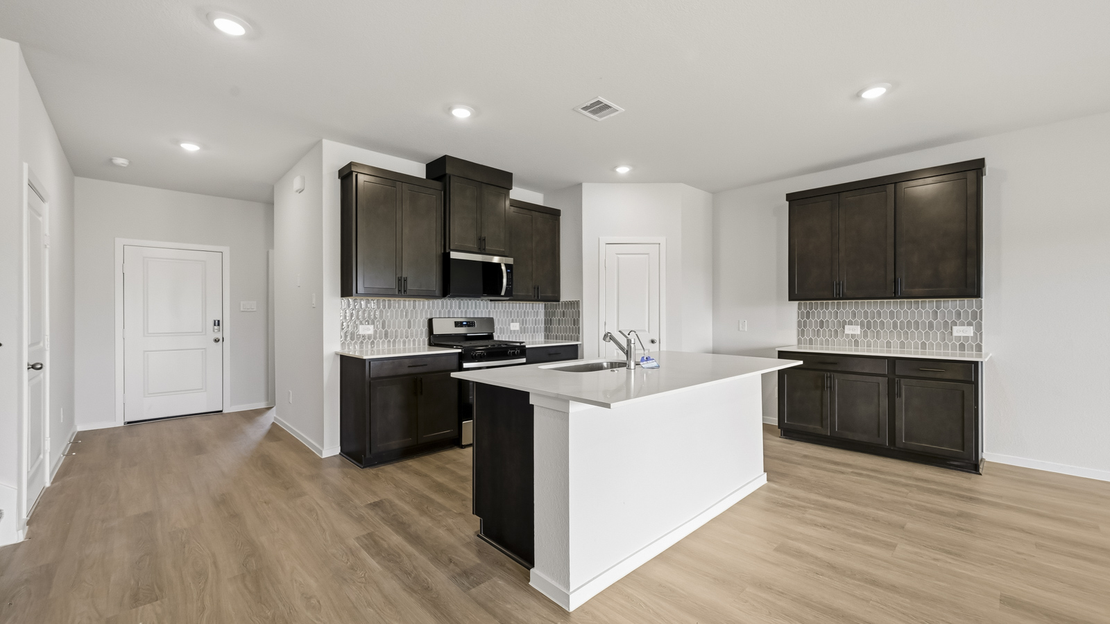 open concept living and dining area with vinyl flooring, large windows, and quartz countertops in Hockley, TX