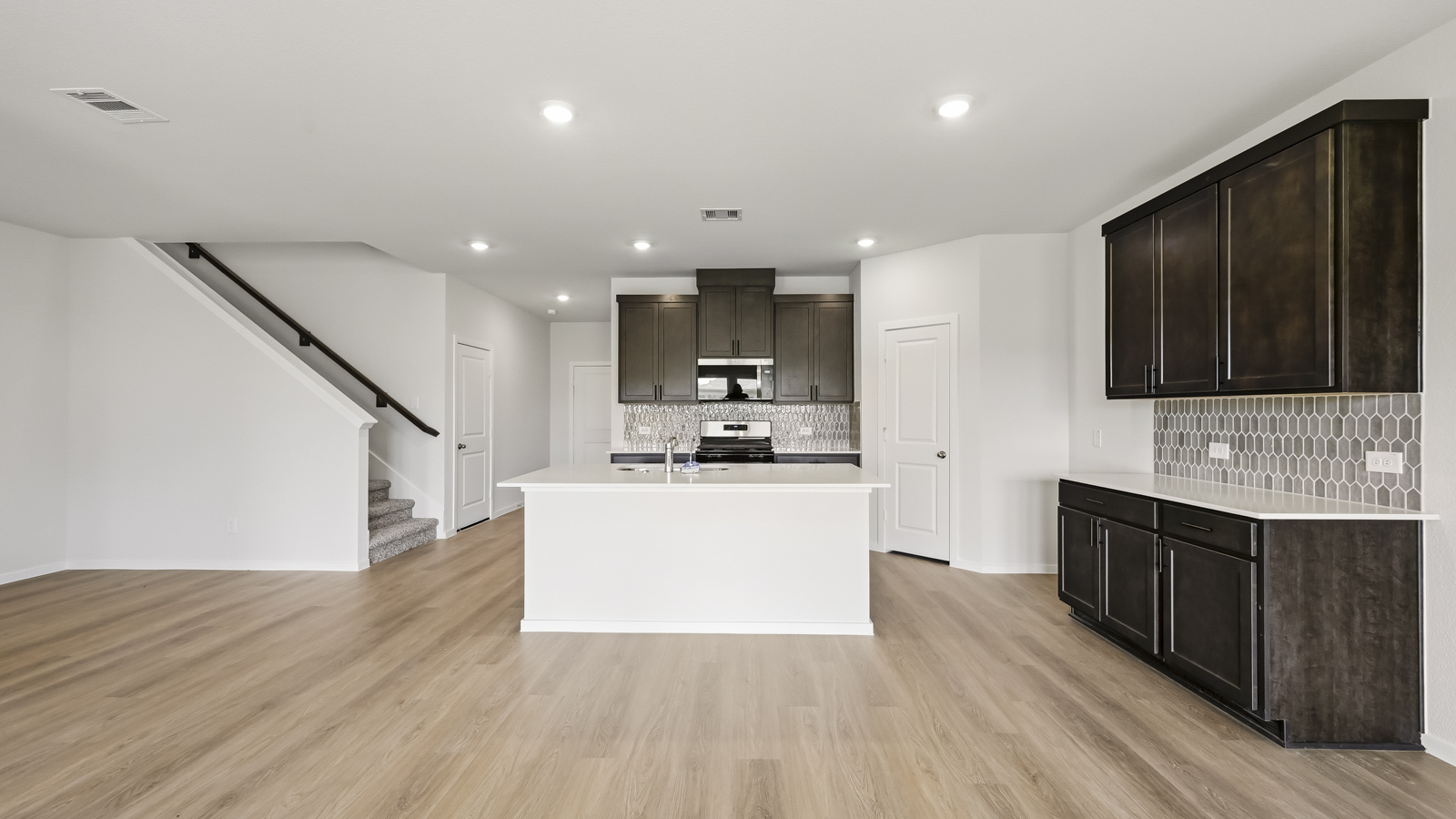 open concept living and dining area with vinyl flooring, large windows, and quartz countertops in Hockley, TX