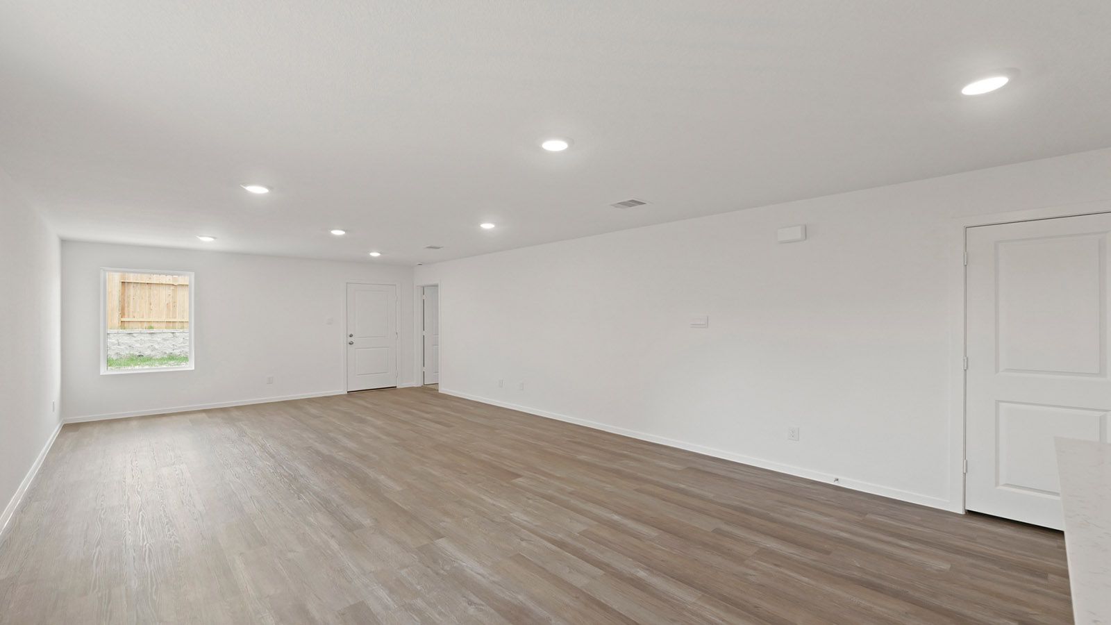 Spacious living area with vinyl flooring