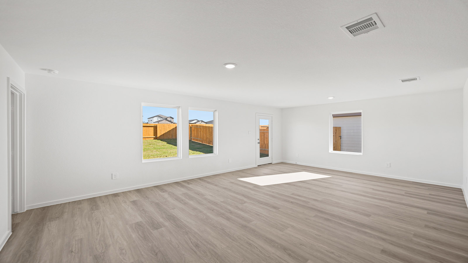 Spacious living area with vinyl flooring