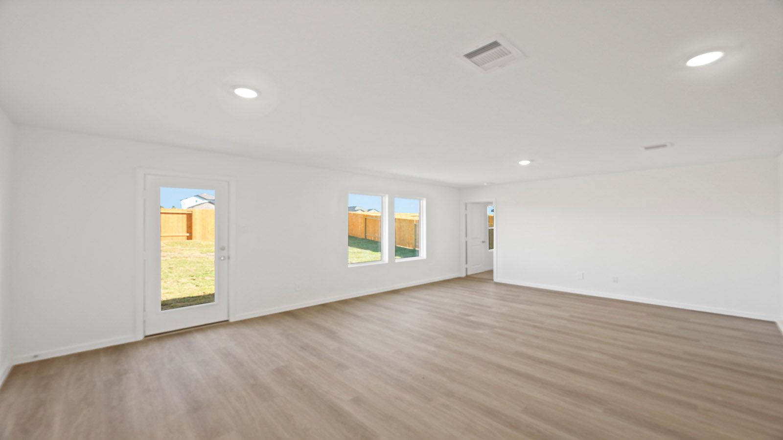 Spacious living area with vinyl flooring