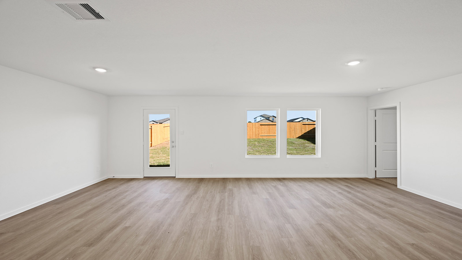 Spacious living area with vinyl flooring