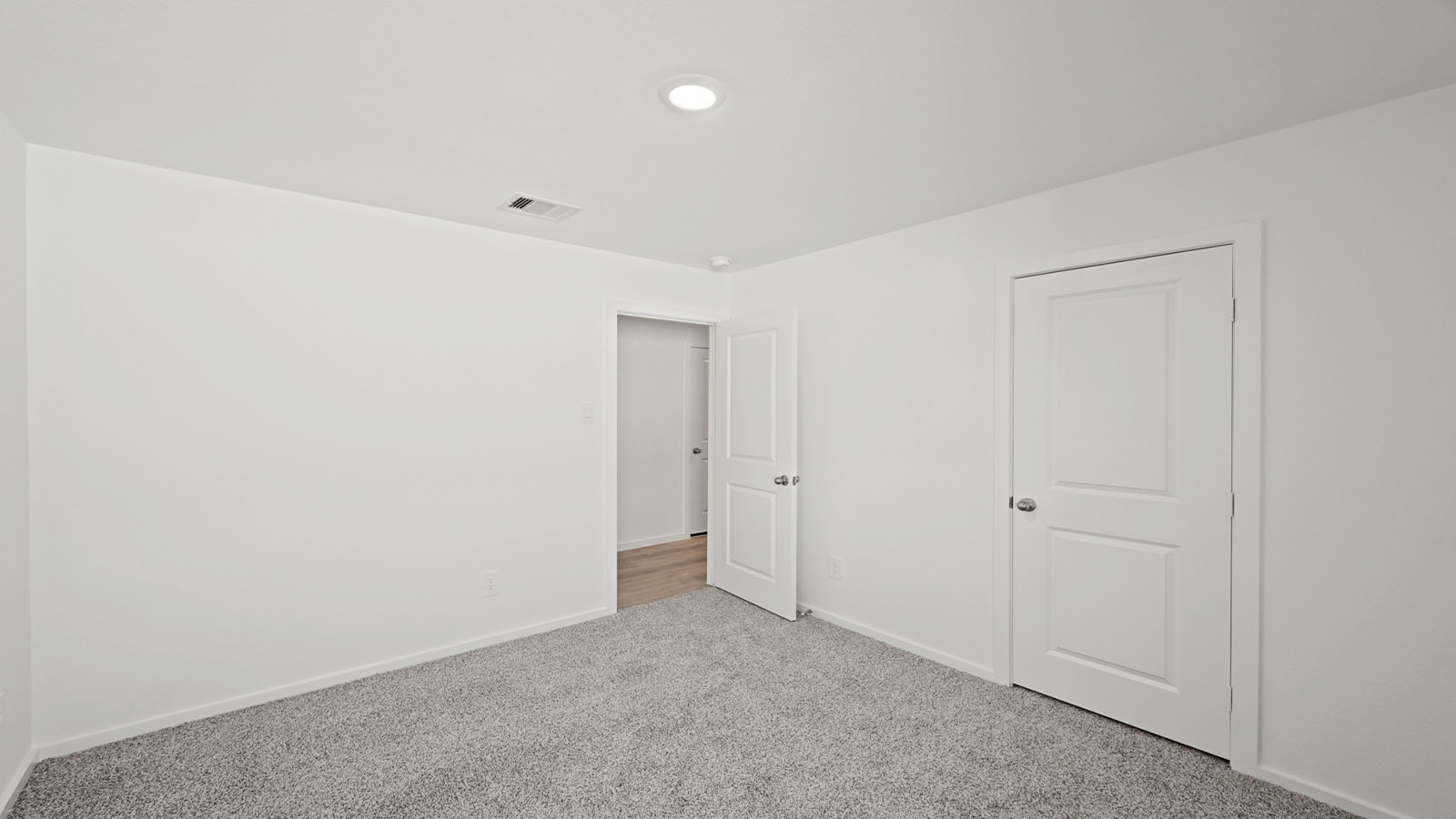 Secondary bedroom with carpet flooring