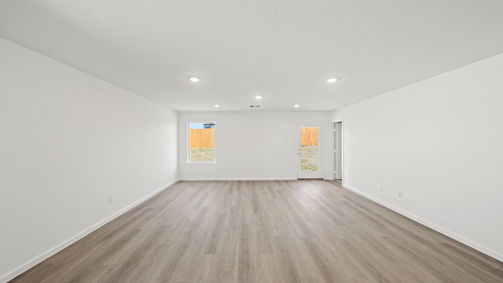 Spacious living area with vinyl flooring