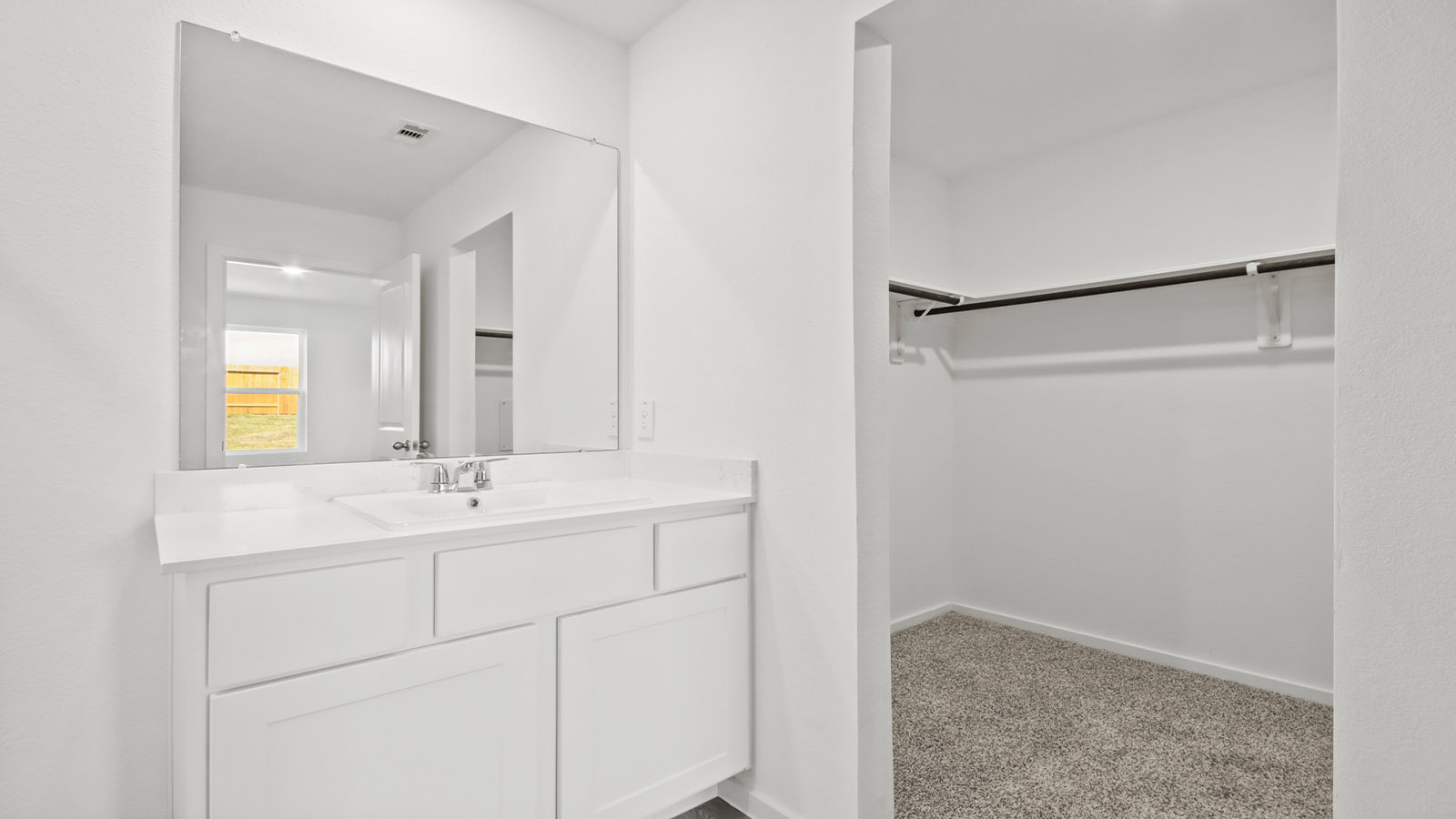 Primary walk-in closet with carpet flooring