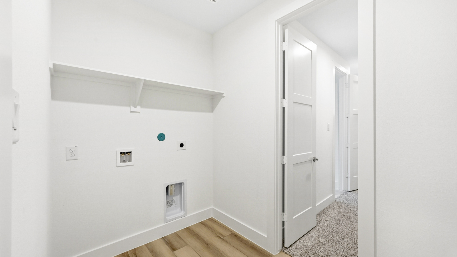 Utility room with storage located off the entry hallway and garage door