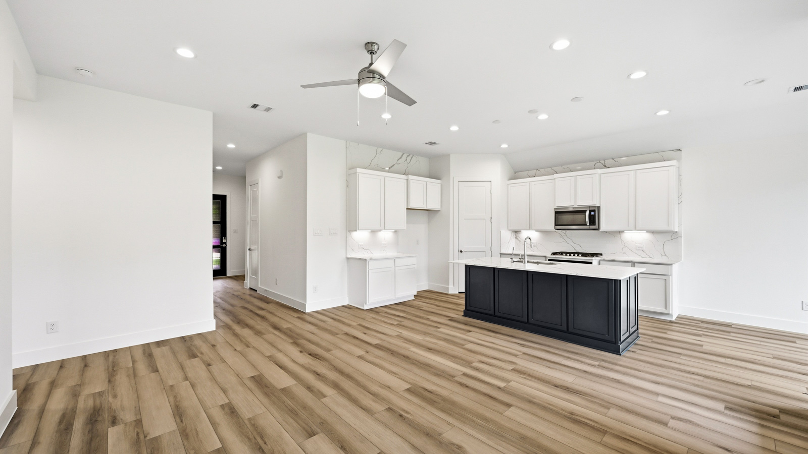 Kitchen with quartz countertops and marden hardware and an island and vinyl floor