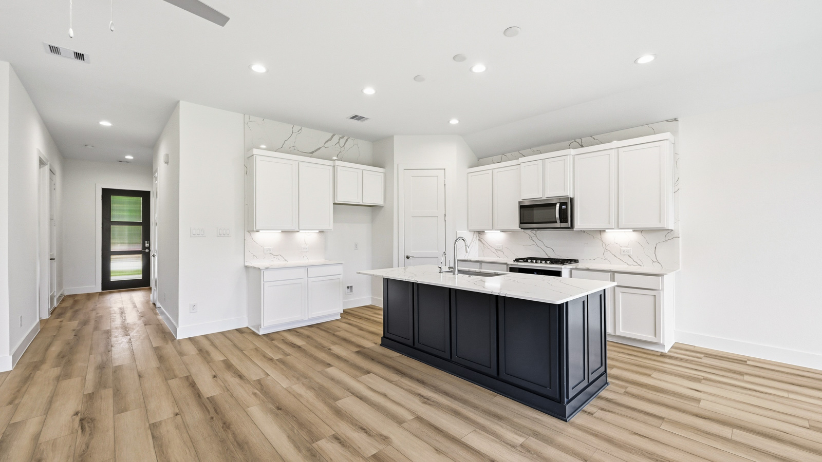Kitchen with quartz countertops and marden hardware and an island and vinyl floor