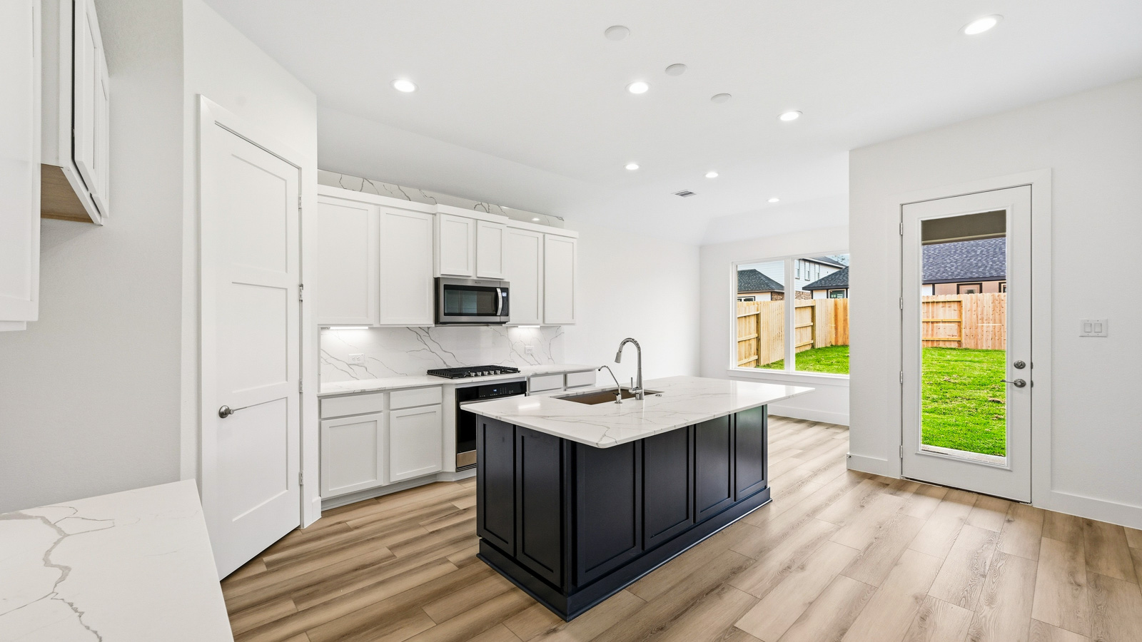 Kitchen with quartz countertops and marden hardware and an island and vinyl floor