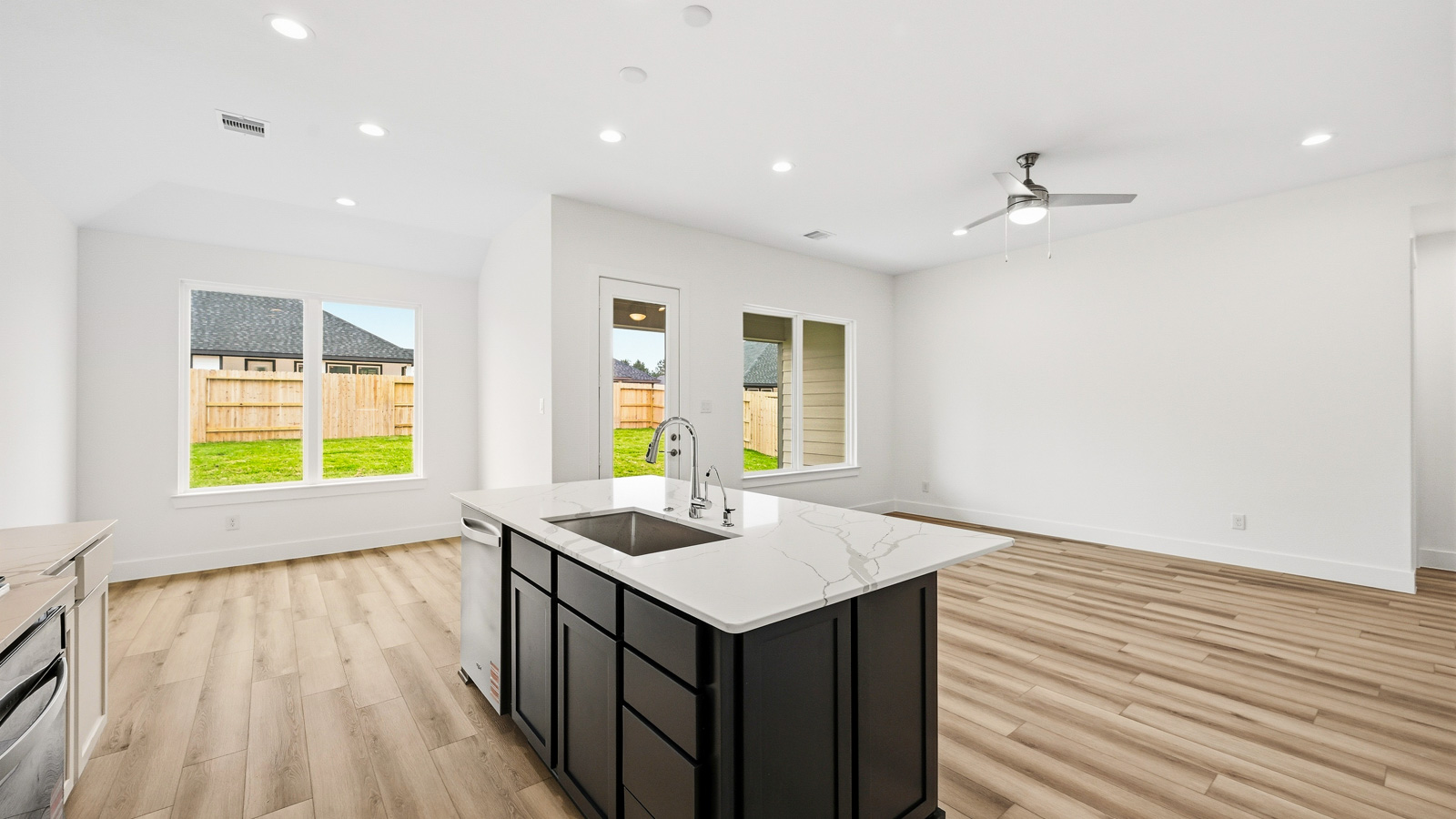 Kitchen with quartz countertops and marden hardware and an island and vinyl floor