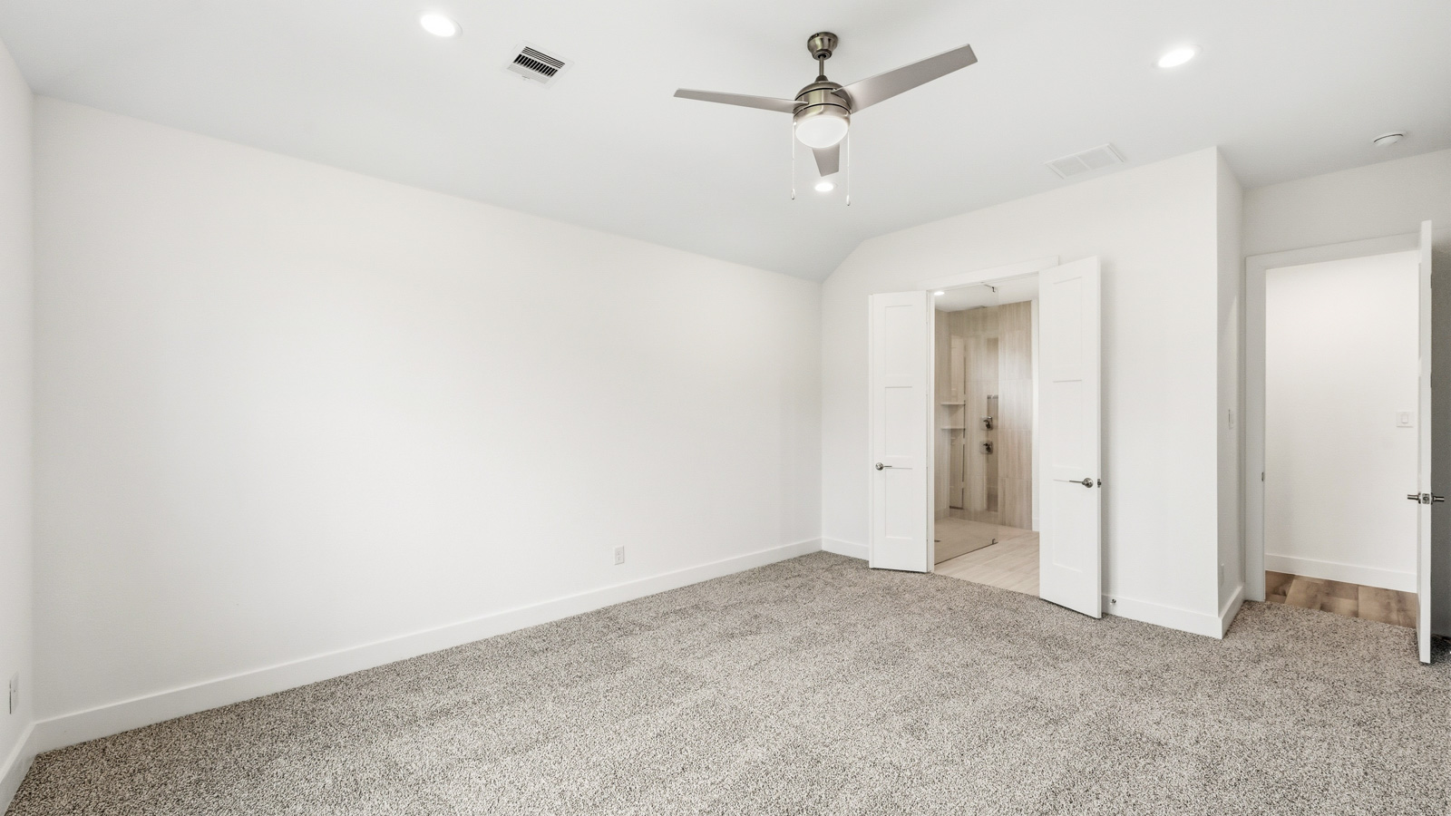 Large Primary bedroom with shag carpet flooring and bright window