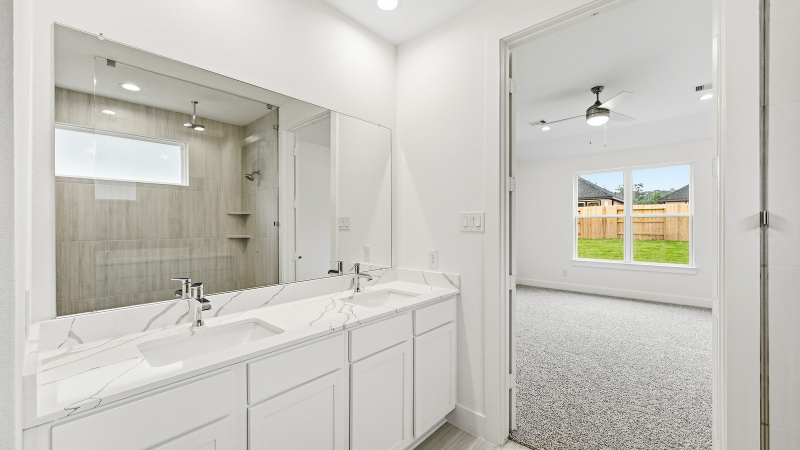 Primary bathroom with stand-alone shower with tiles and semi frameless glass in Magnolia TX