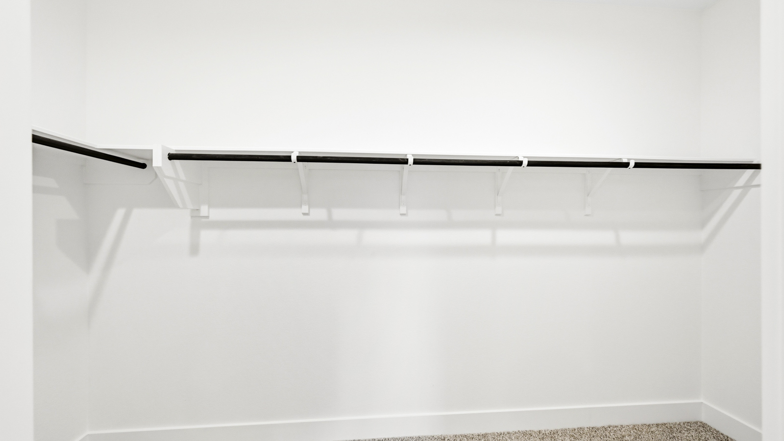 Primary bedroom walk-in closet with carpet flooring in Mill Creek community in Magnolia TX