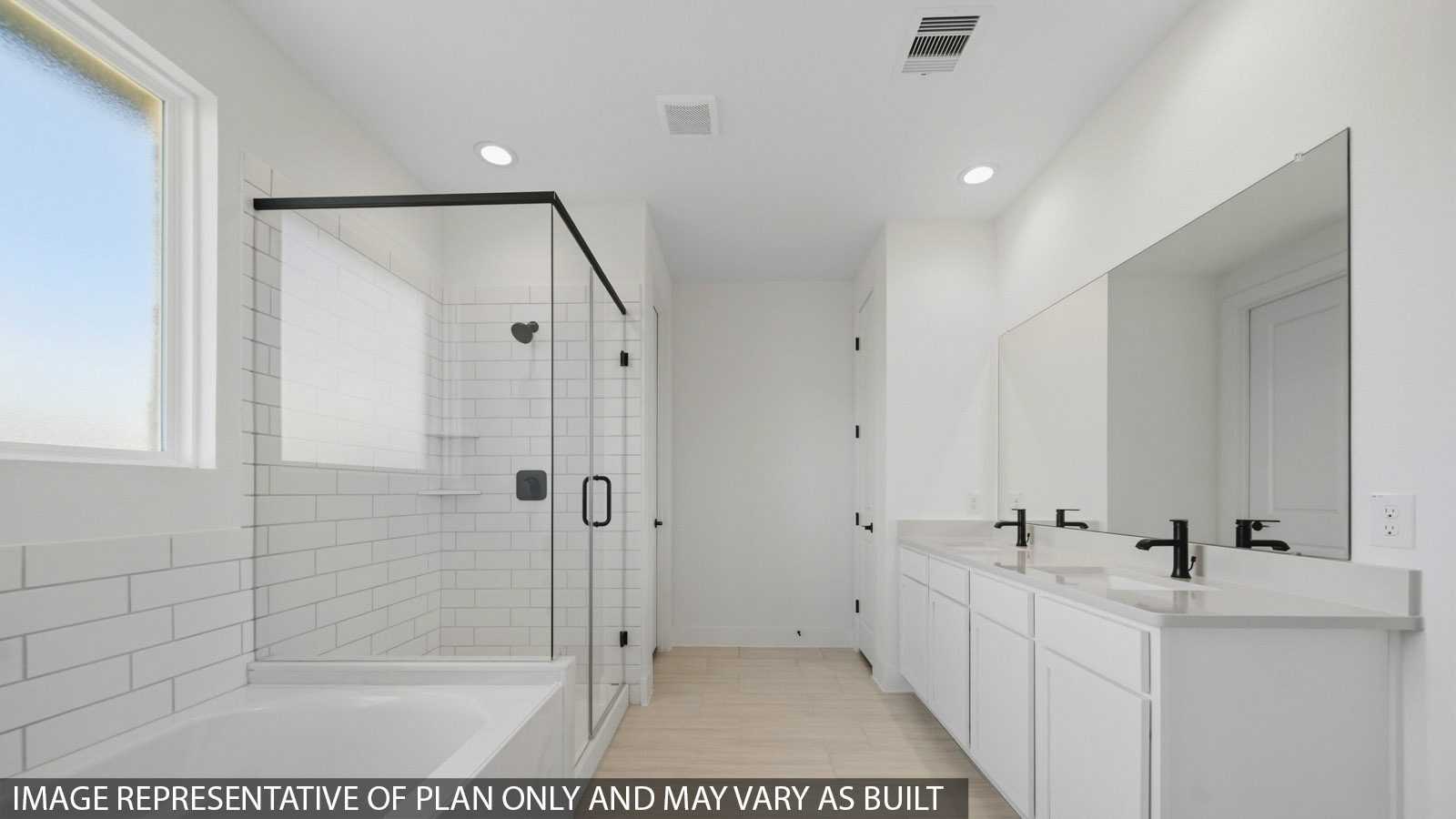 Primary bathroom with soaker tub and tile shower with semi frameless glass in Magnolia TX