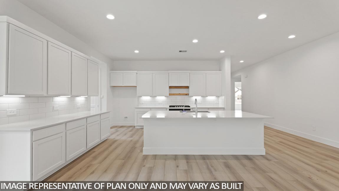 Kitchen with quartz countertops and marden hardware and an island and vinyl floor