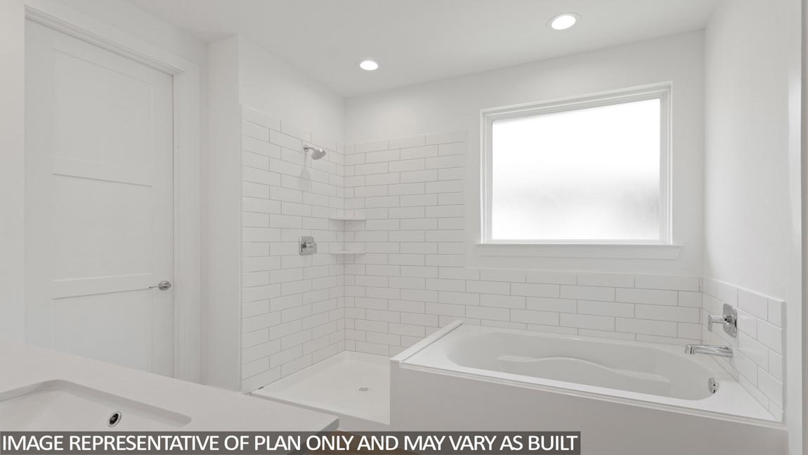 Primary bathroom with soaker tub and tile shower with semi frameless glass in Magnolia TX