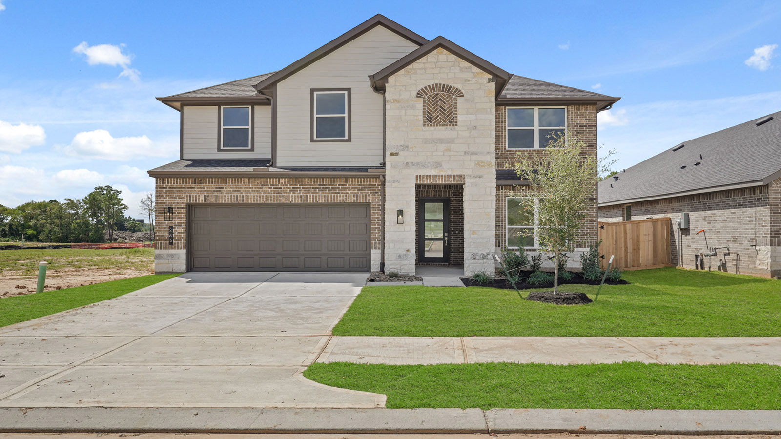 Two story home with two car garage with brick and siding in New Waverly TX