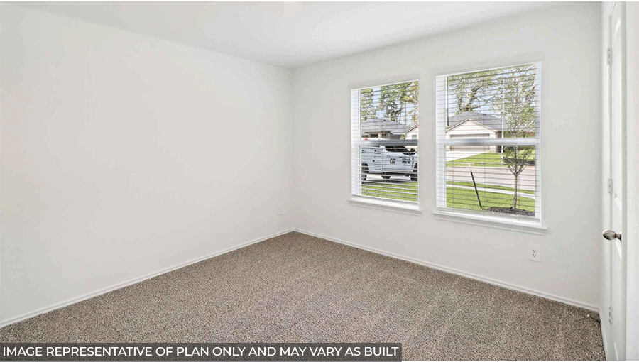 Secondary bedroom with carpet flooring