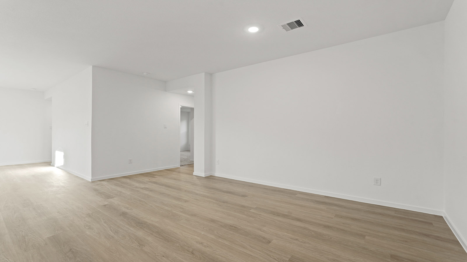 Spacious living area with vinyl flooring