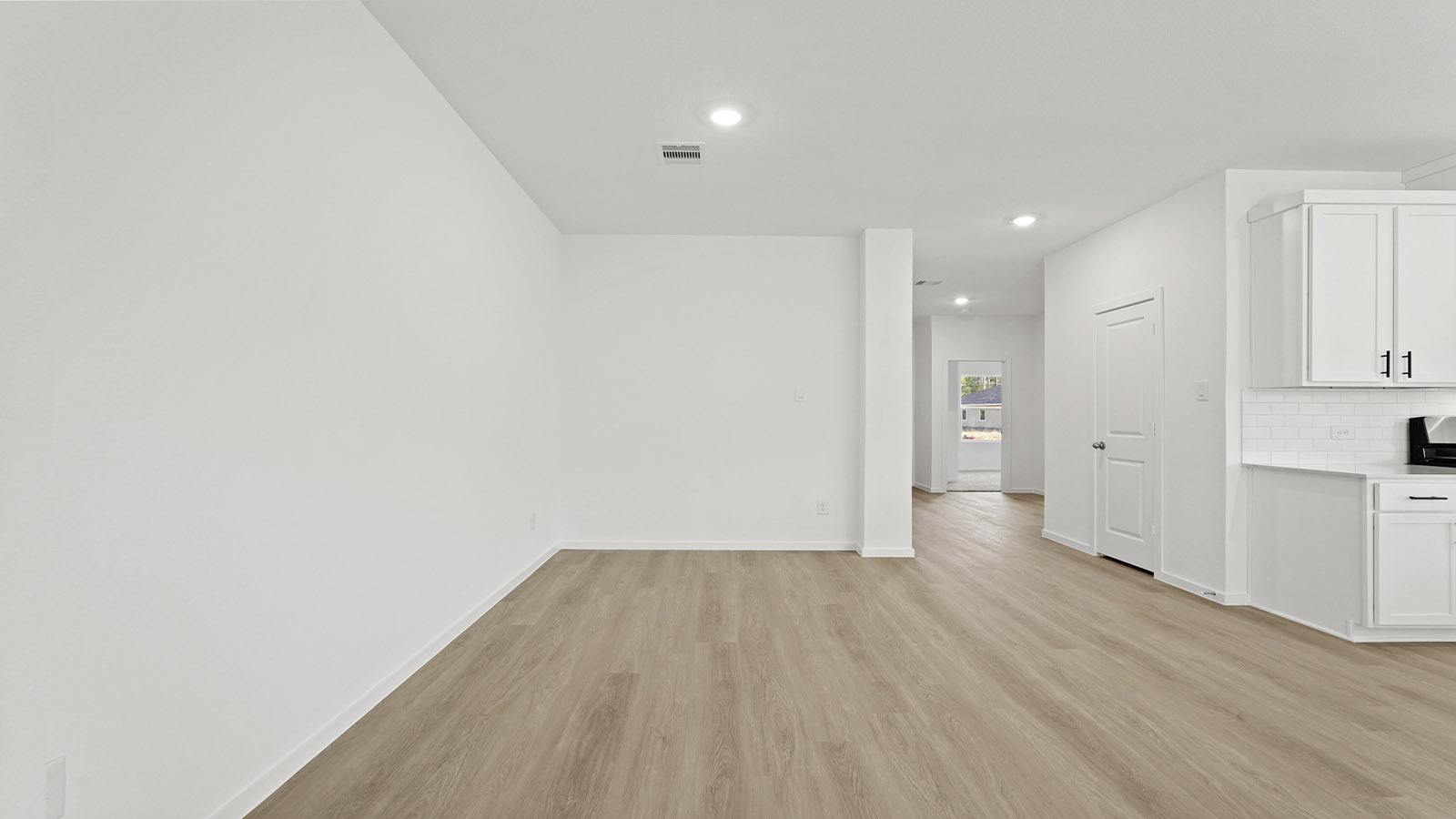 Spacious living area with vinyl flooring