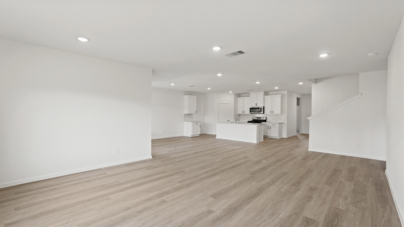 Spacious living area with vinyl flooring