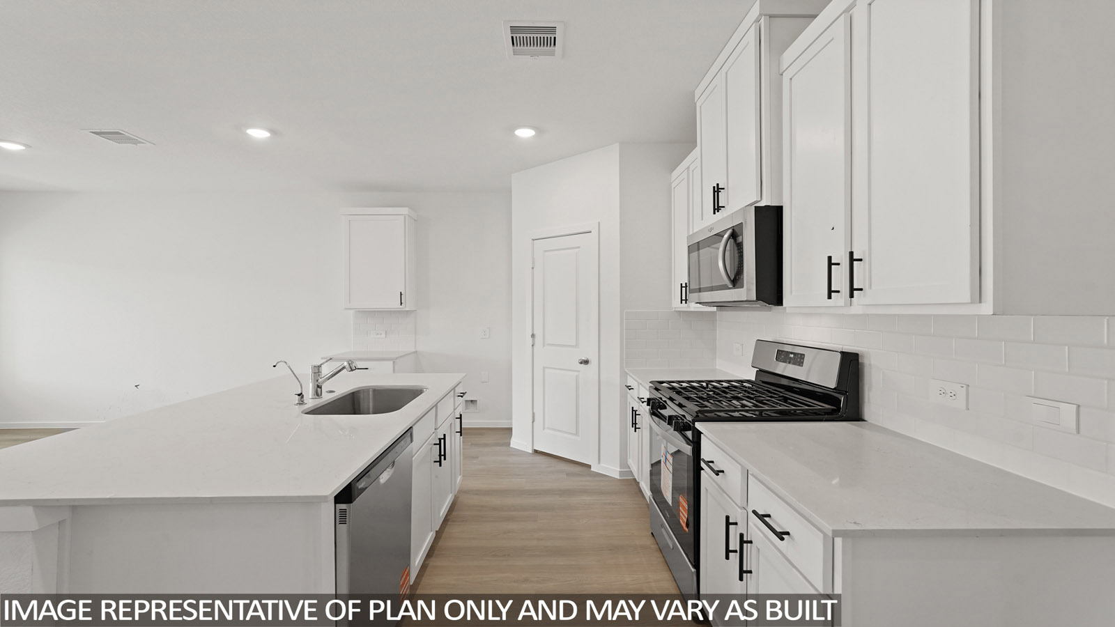 Kitchen with stainless steel appliances, quartz countertops and modern hardware and an island and vinyl floor