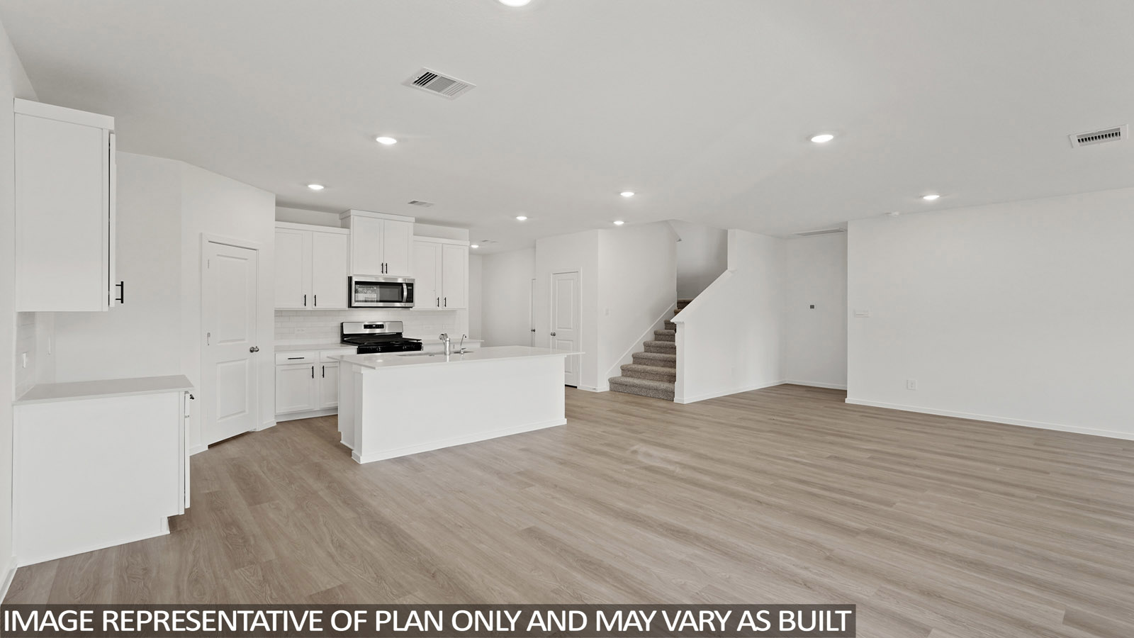 Kitchen with stainless steel appliances, quartz countertops and modern hardware and an island and vinyl floor