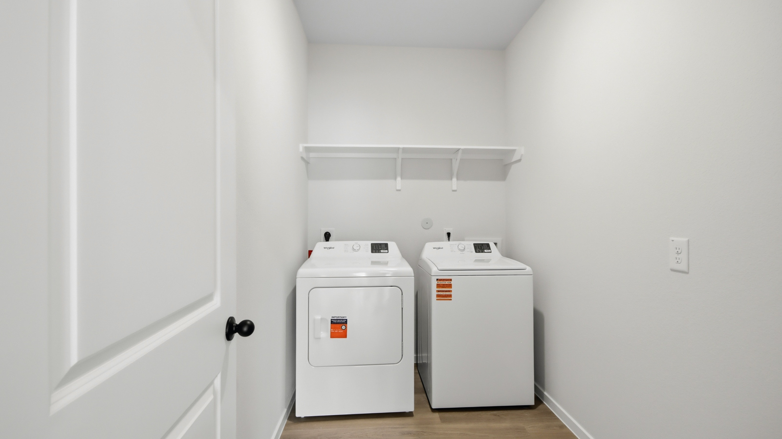 Utility room with storage located off the entry hallway and garage door